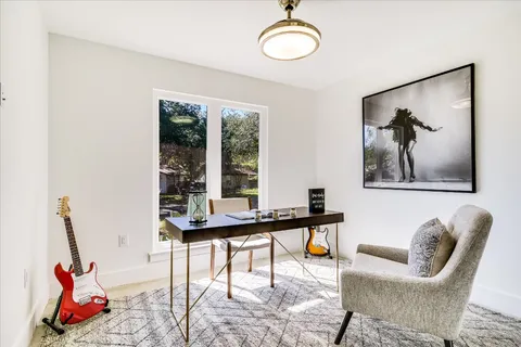 a view of a workspace with furniture and a window