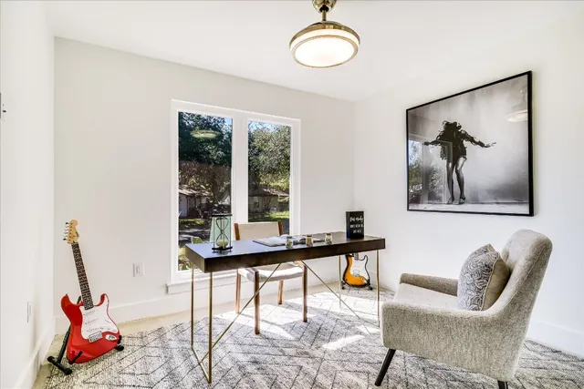 a view of a workspace with furniture and a window