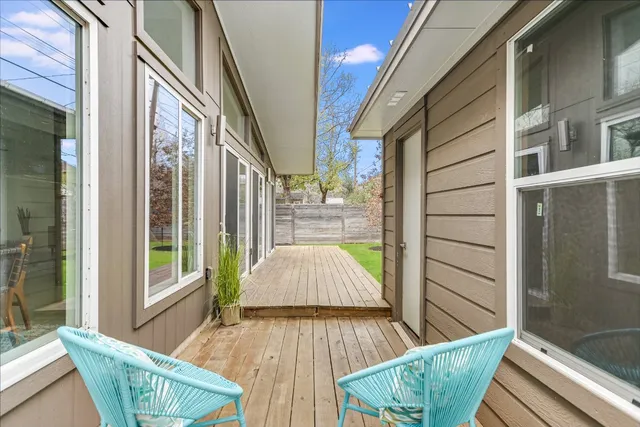 a view of balcony with two chairs and wooden floor