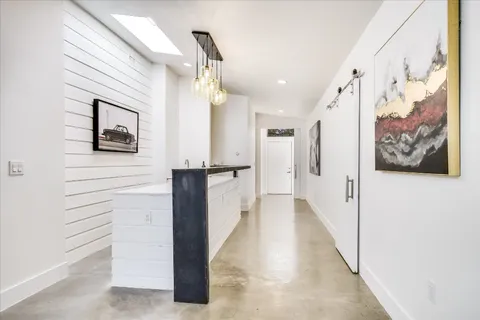 a view of hallway with stairs and a painting on the wall