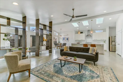a living room with furniture wooden floor and a chandelier