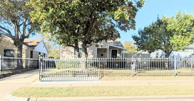 a view of a house with a fence and a tree