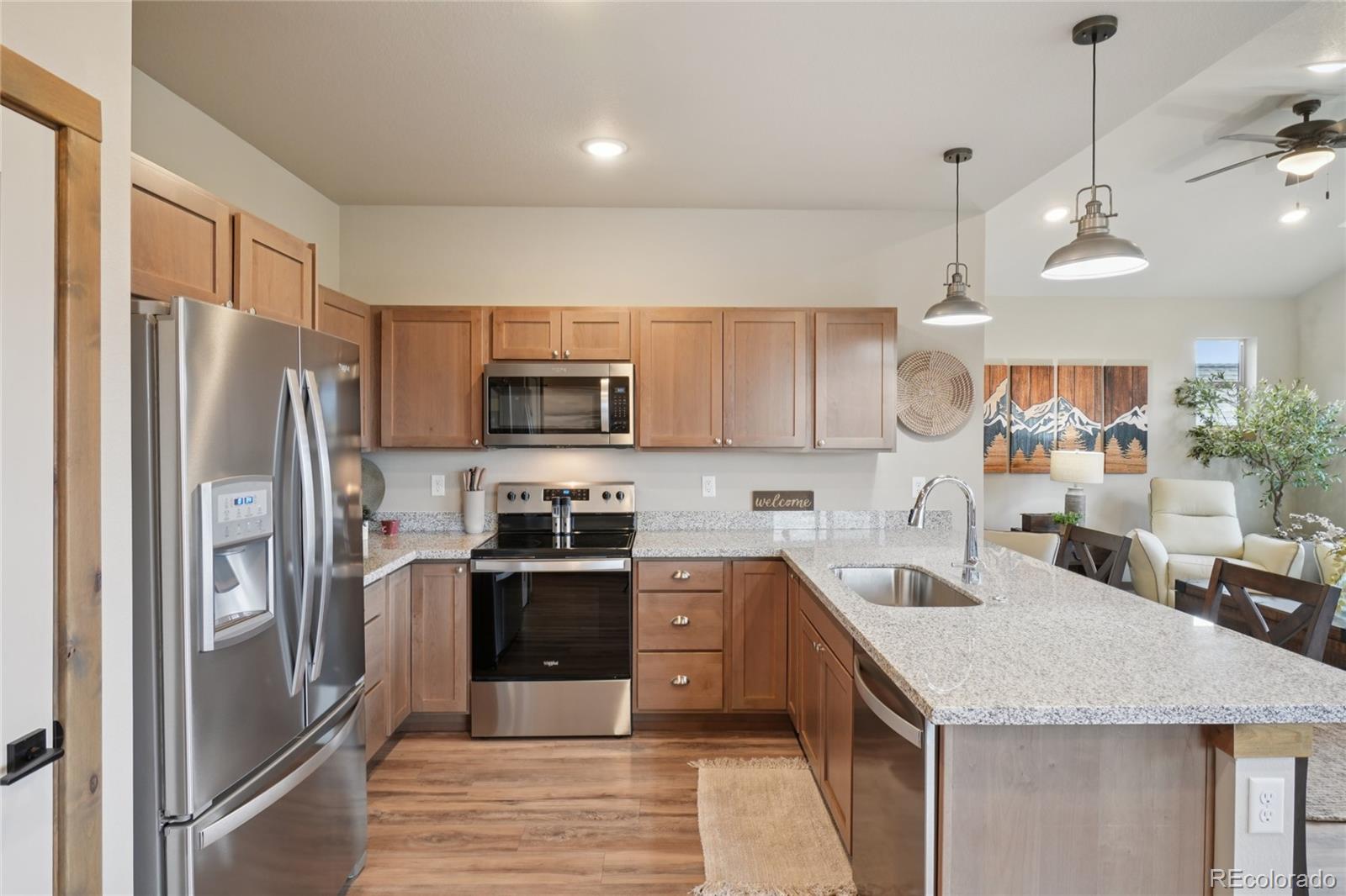1700 Wildfire Road, Unit 301 Estes Park, CO 80517 - Photo 15 of 38 a kitchen with stainless steel appliances granite countertop a refrigerator a sink dishwasher a oven with white cabinets and wooden floor