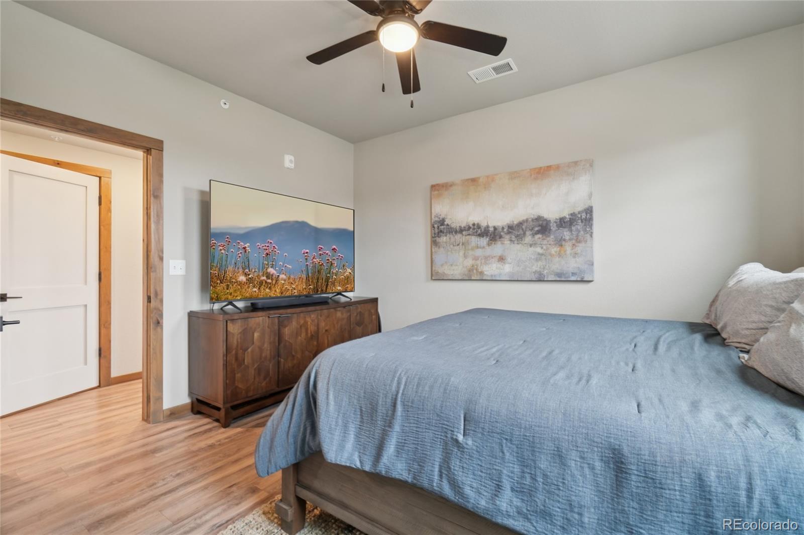 1700 Wildfire Road, Unit 301 Estes Park, CO 80517 - Photo 21 of 38 a bedroom with a bed and a chandelier
