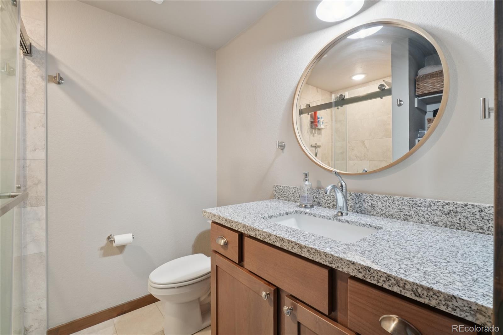 1700 Wildfire Road, Unit 301 Estes Park, CO 80517 - Photo 22 of 38 a bathroom with a granite countertop sink and a mirror