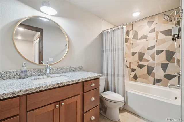a view of a hallway with wooden floor and a bathroom