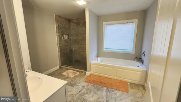 a bathroom with a tub shower and sink