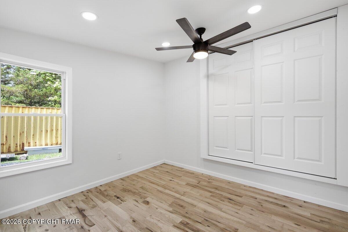 155 Blooming Grove Road Hawley, PA 18428 - Photo 24 of 41 an empty room with wooden floor fan and windows