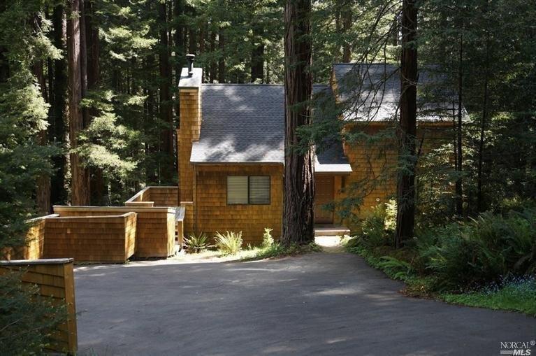a front view of a house with a yard and tree s