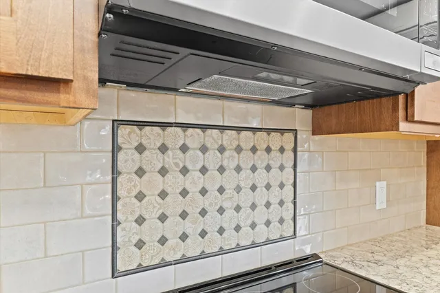 a view of kitchen with granite countertop cabinets and refrigerator