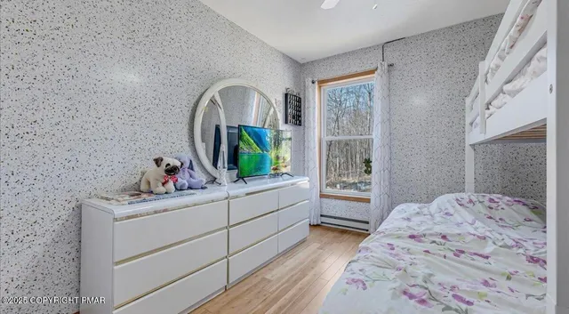 a view of a bedroom with wooden floor and windows