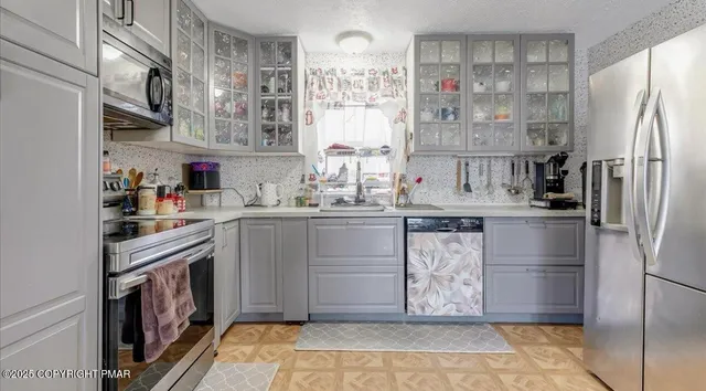 a kitchen with stainless steel appliances granite countertop a refrigerator and a sink