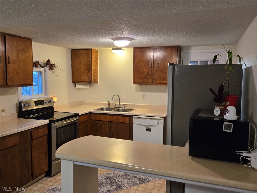 3186 Styx Hill Road Medina, OH 44256 - Photo 8 of 17 Kitchen featuring light appliances with stainless steel finishes, a textured ceiling, and sink