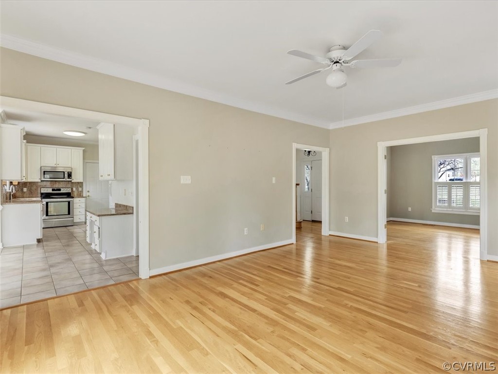 16219 Dragonnade Trail Midlothian, VA 23113 - Photo 15 of 39 a view of an empty room with wooden floor and a kitchen