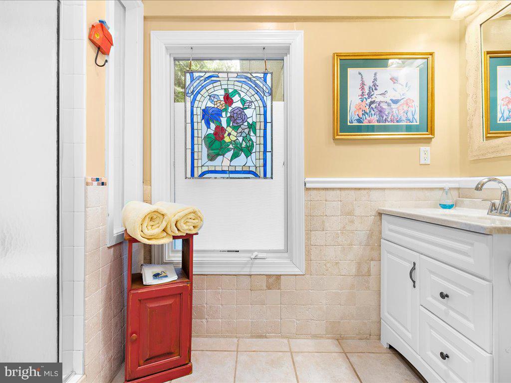 720 Southeast Creek Road Church Hill, MD 21623 - Photo 26 of 53 a bathroom with a sink a mirror and painting on the wall