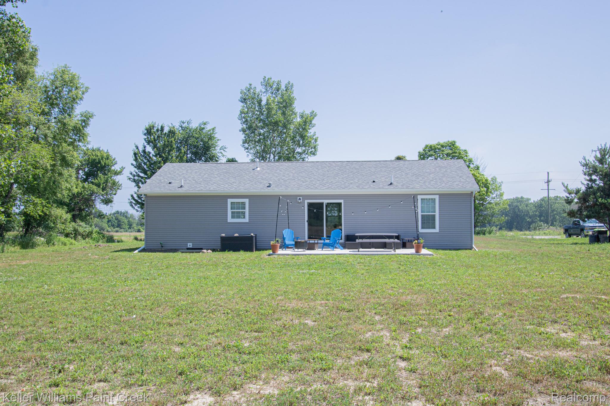 5200 Babcock Road Lexington, MI 48450 - Photo 28 of 31 Expansive grass lawn surrounding a single-story residence with gray siding and a gray shingle roof