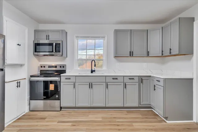 a kitchen with stainless steel appliances granite countertop a stove a sink and a microwave