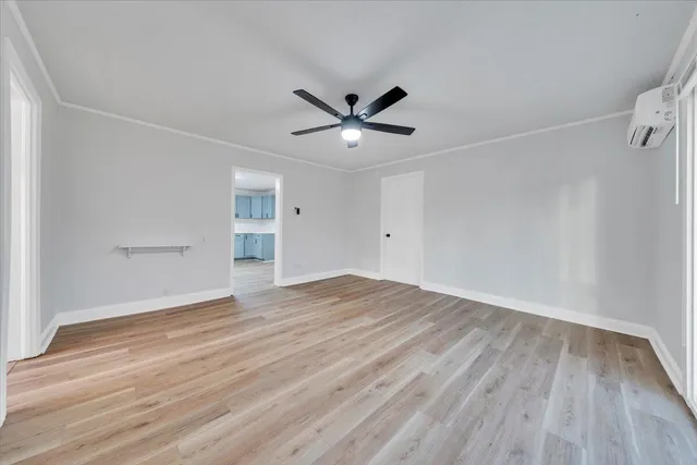 a view of a room with wooden floor and a ceiling fan