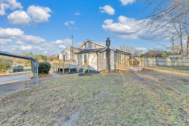 a view of a big house with a big yard and large tree