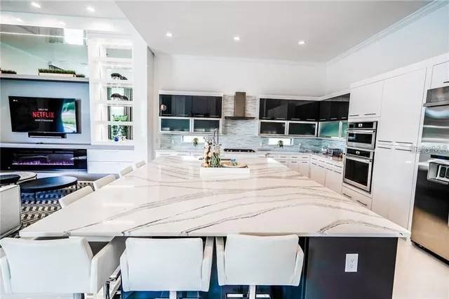 a kitchen with kitchen island a stove and a sink