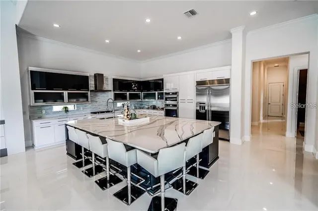 a large kitchen with kitchen island a sink table and chairs