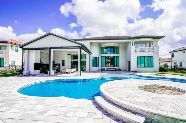 a view of a house with swimming pool and a dining table and chairs