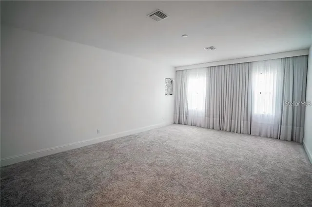 an empty room with windows and closet