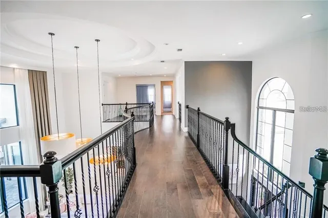 a view of a hallway with wooden floor and stairs