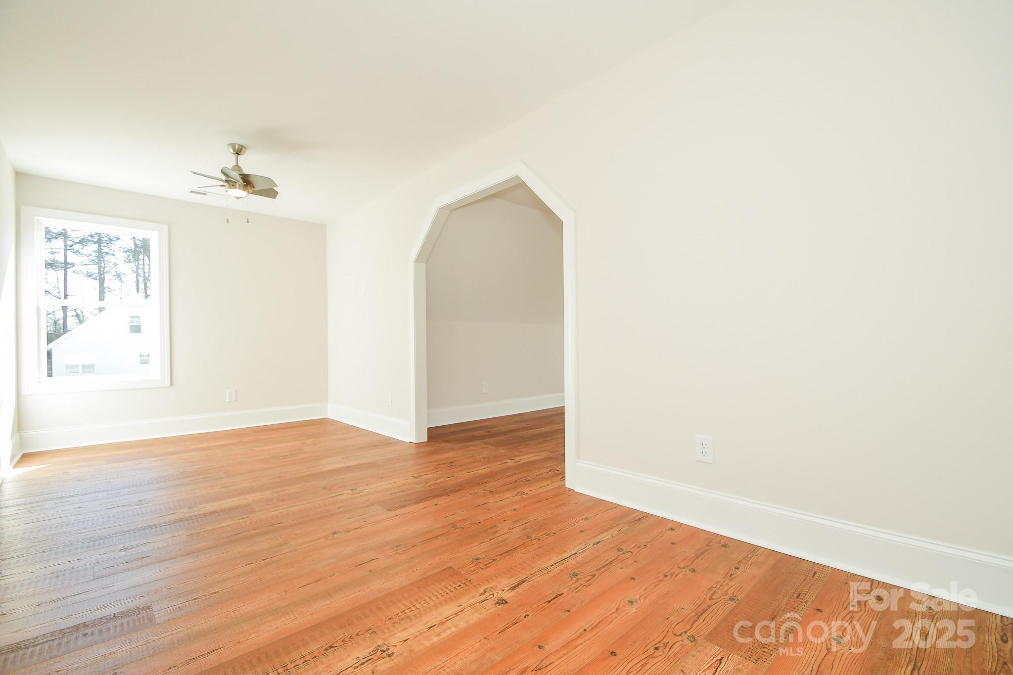 7805 Medlin Road Monroe, NC 28112 - Photo 11 of 13 a view of a room with wooden floor and a ceiling fan