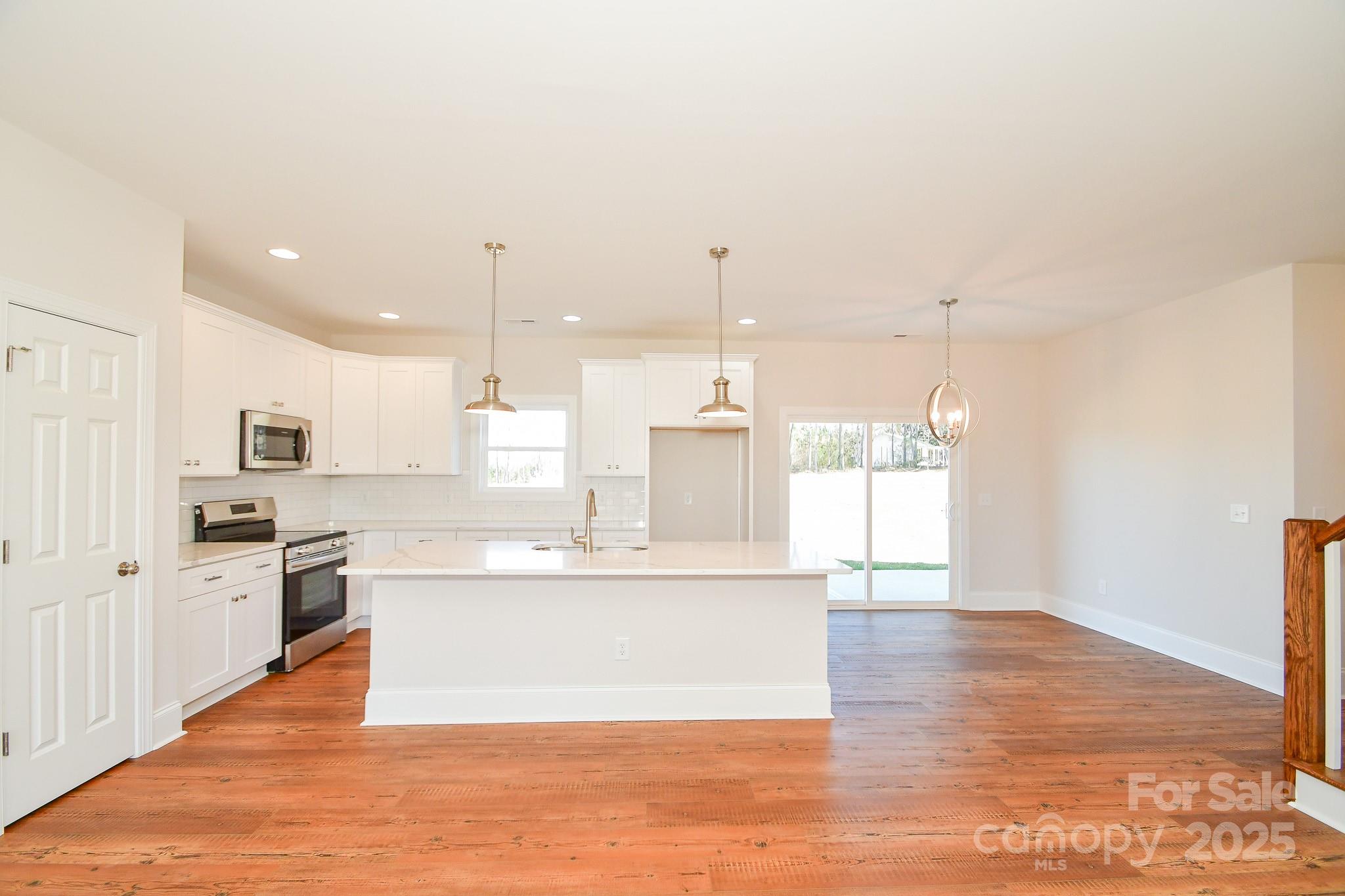 7805 Medlin Road Monroe, NC 28112 - Photo 5 of 13 a large kitchen with stainless steel appliances kitchen island granite countertop a large cabinets and wooden floor