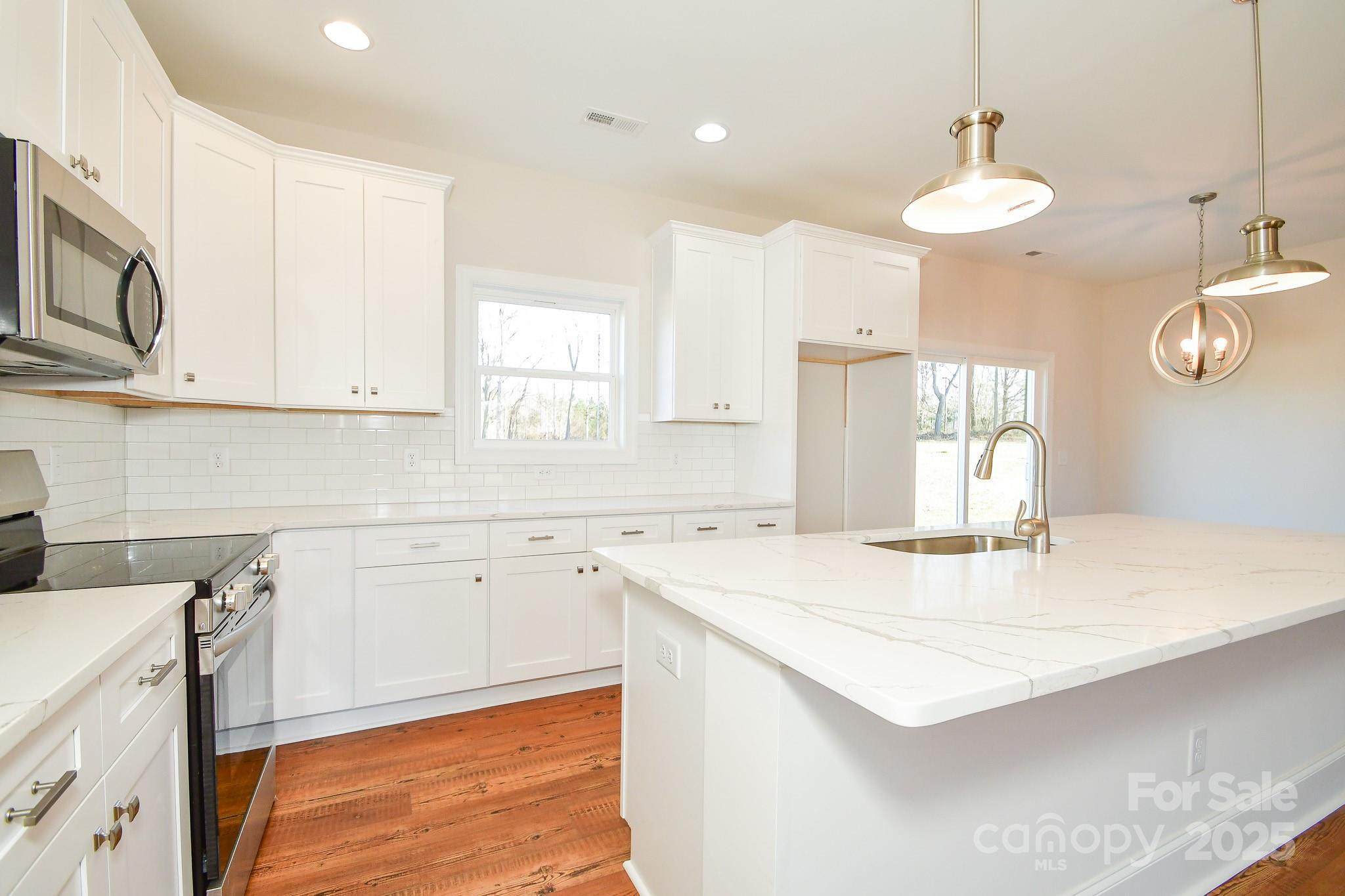 7805 Medlin Road Monroe, NC 28112 - Photo 7 of 13 a kitchen with a sink a window and cabinets