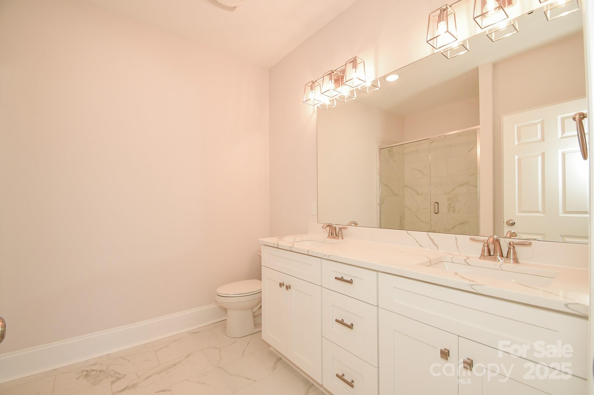 7805 Medlin Road Monroe, NC 28112 - Photo 9 of 13 a bathroom with a sink a toilet and a mirror