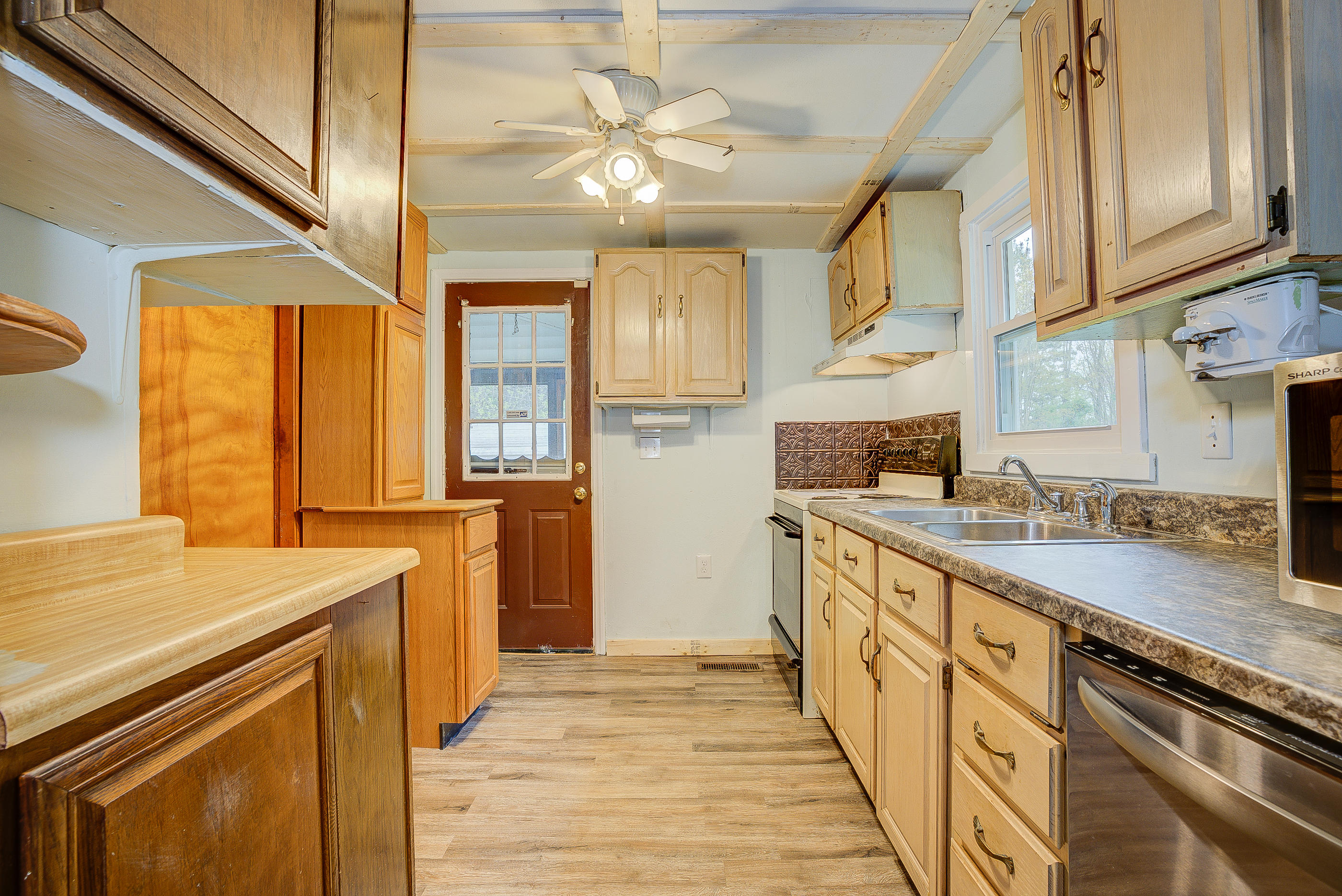 3110 Thomasson Mill Road Goodview, VA 24095 - Photo 12 of 35 a kitchen with stainless steel appliances granite countertop a sink a stove cabinets counter space and a window