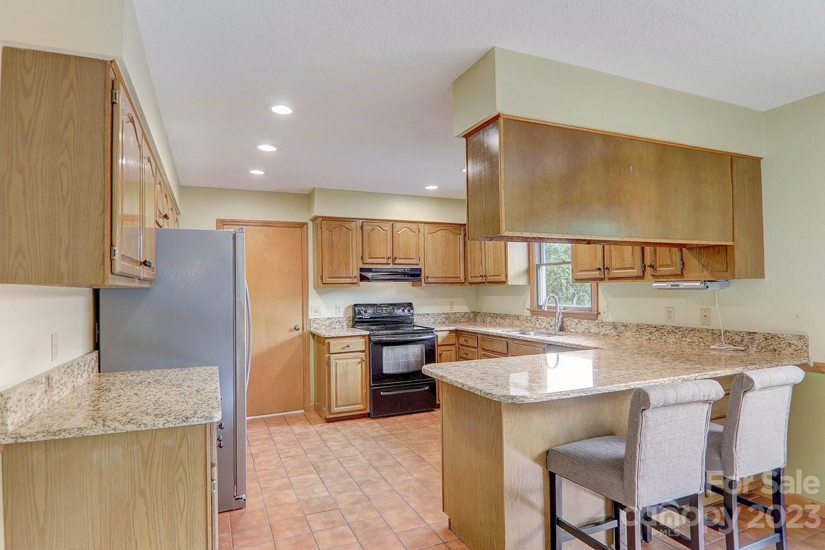 110 Oak Hill Road Candler, NC 28715 - Photo 12 of 37 a kitchen with stainless steel appliances granite countertop a sink counter space and a refrigerator