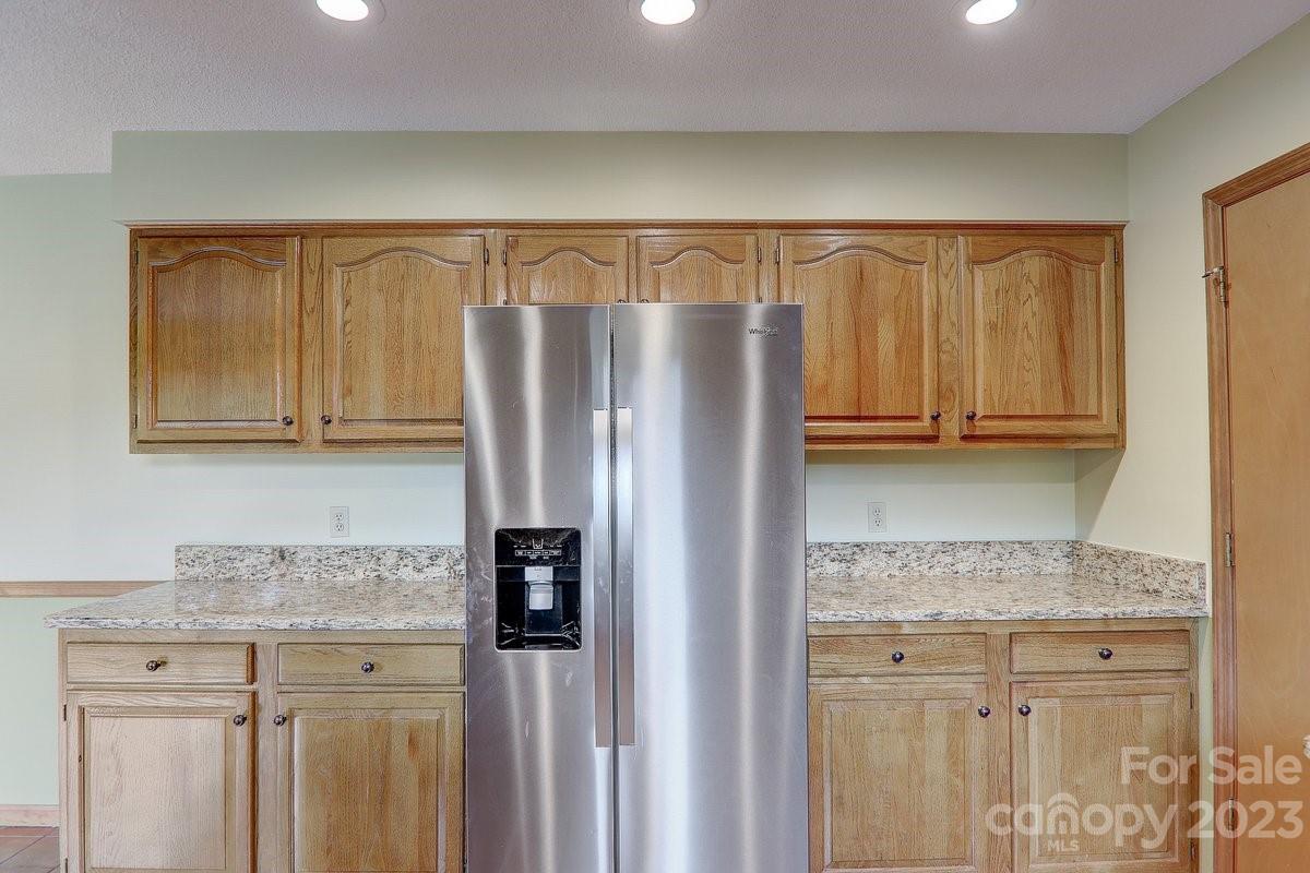 110 Oak Hill Road Candler, NC 28715 - Photo 14 of 37 a kitchen with granite countertop a refrigerator and cabinets