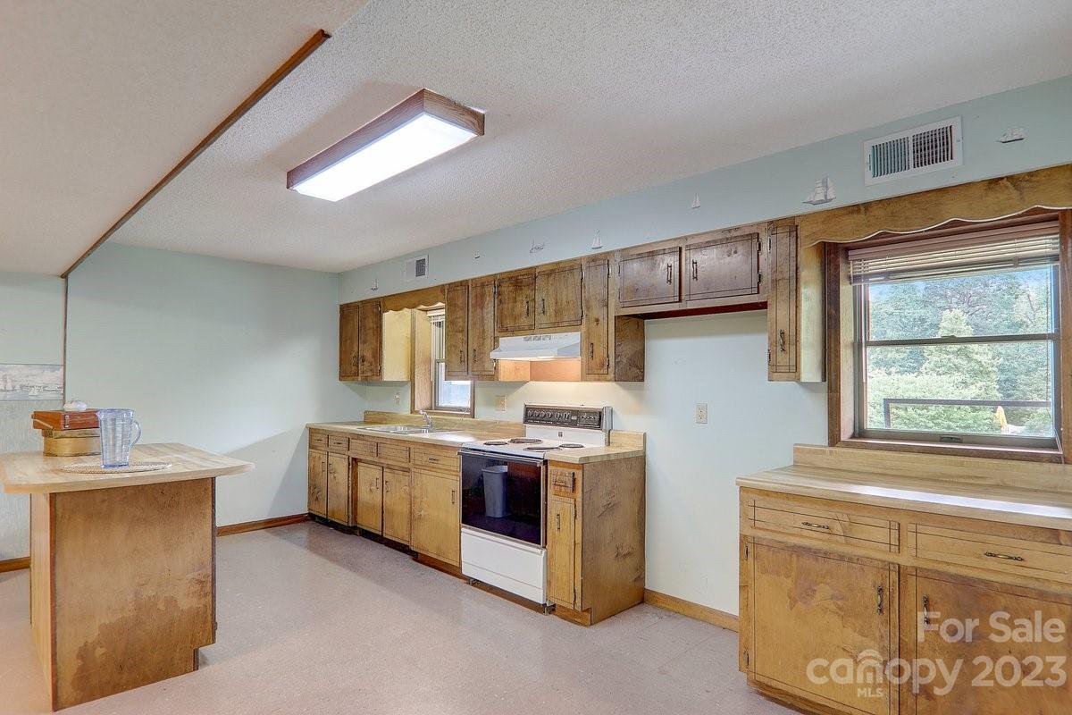 110 Oak Hill Road Candler, NC 28715 - Photo 29 of 37 a kitchen with stainless steel appliances granite countertop a stove a sink and a refrigerator