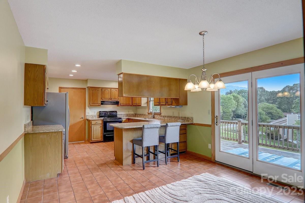 110 Oak Hill Road Candler, NC 28715 - Photo 10 of 37 a open kitchen with stainless steel appliances granite countertop a stove top oven a sink and kitchen island