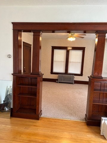 a view of a living room that has a large window and dresser