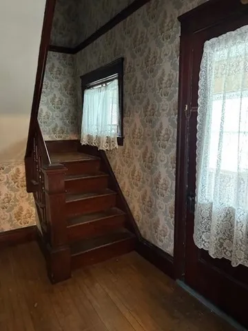 a view of entryway with wooden floor and front door