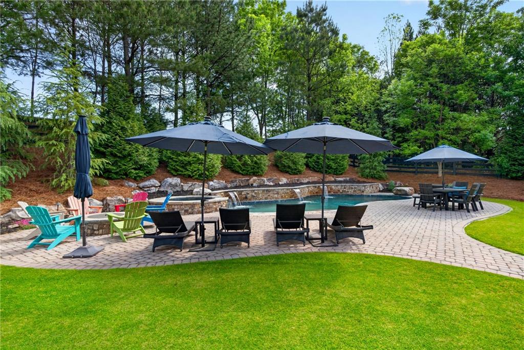 130 Providence Oaks Pointe Milton, GA 30004 - Photo 3 of 89 a view of a swimming pool with lawn chairs under an umbrella