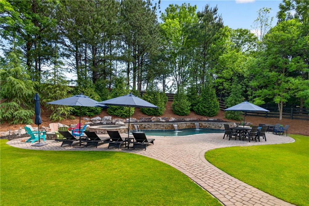 130 Providence Oaks Pointe Milton, GA 30004 - Photo 78 of 89 a view of a swimming pool with lawn chairs under an umbrella