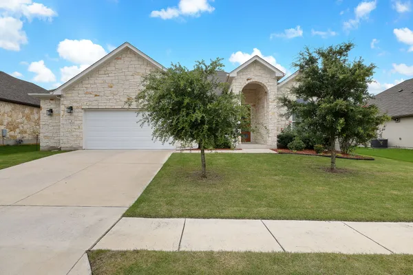 a front view of a house with a yard and garage