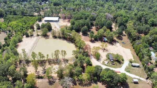 an aerial view of residential houses with outdoor space and trees