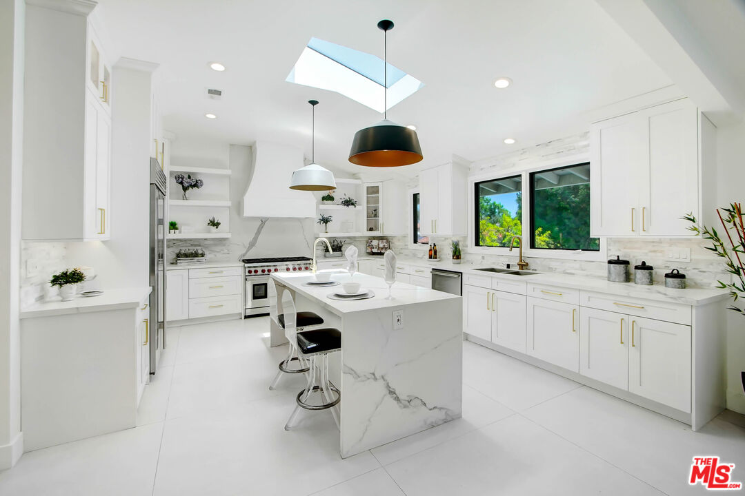 4166 Crisp Canyon Road Sherman Oaks, CA 91403 - Photo 16 of 54 a kitchen with stainless steel appliances a sink a stove a refrigerator and white cabinets