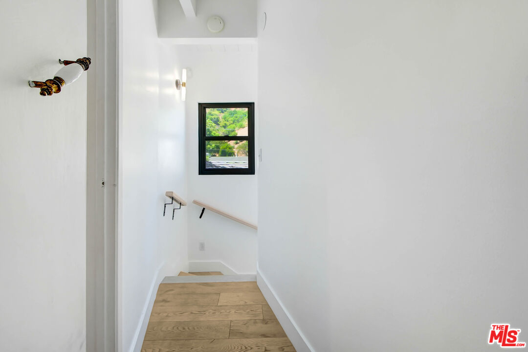 4166 Crisp Canyon Road Sherman Oaks, CA 91403 - Photo 35 of 54 a view of a hallway with wooden floor and a potted plant
