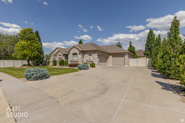 2327 Bluff Ridge Drive Syracuse, UT 84075 - Photo 3 of 66 Stone facade residence featuring a multi-car garage, concrete driveway, and mature landscaping