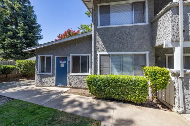 a front view of a house with a garden and plants