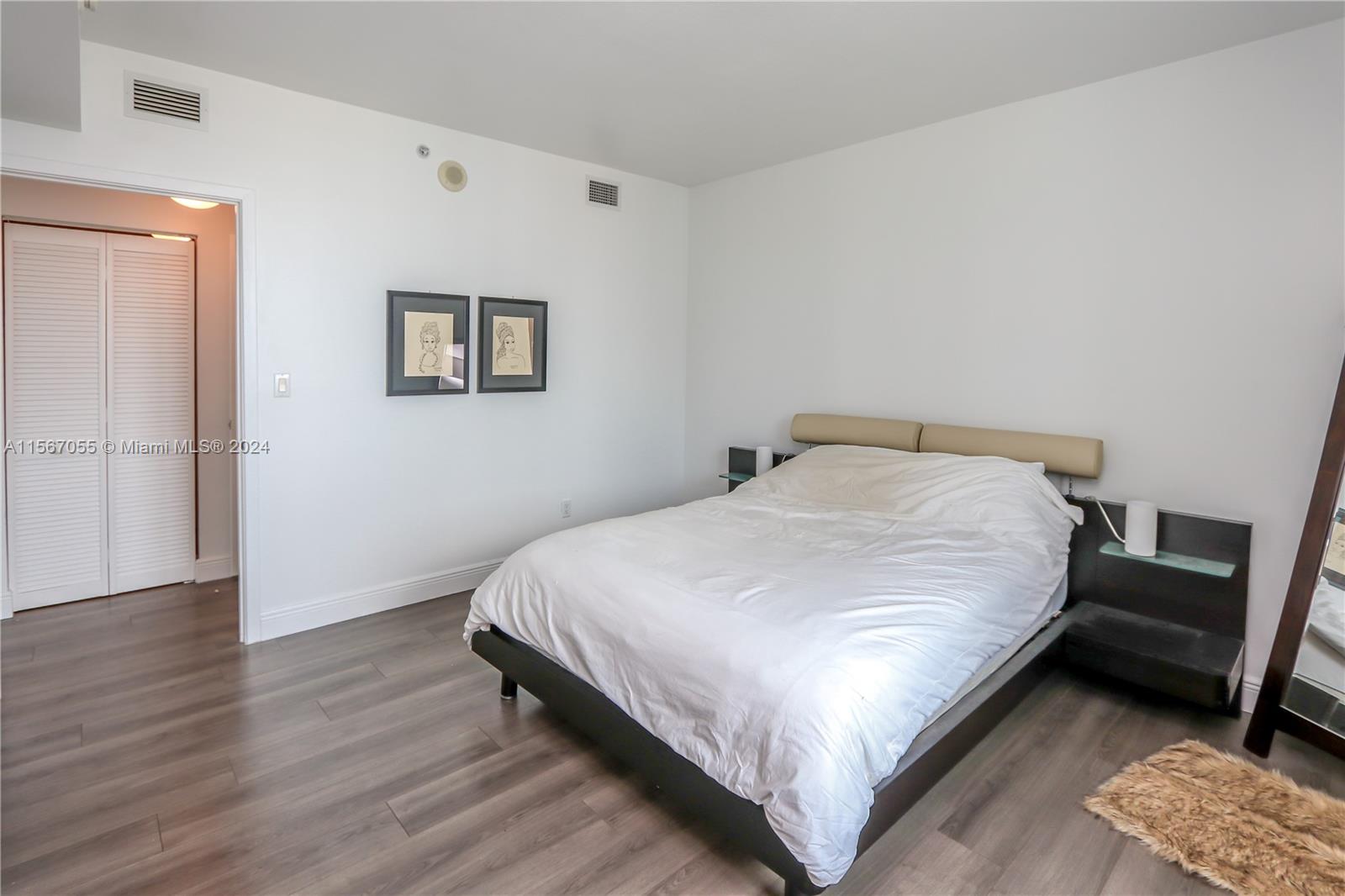 335 South Biscayne Boulevard, Unit 2703 Miami, FL 33131 - Photo 11 of 55 a bedroom with a bed and wooden floor