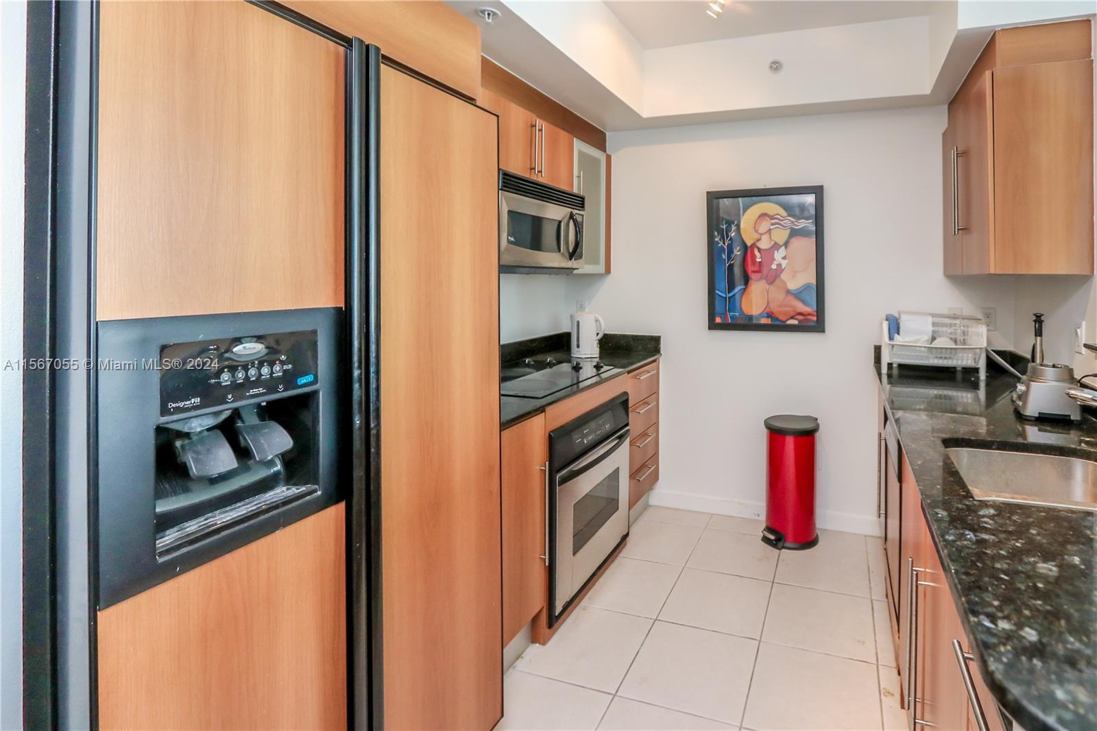 335 South Biscayne Boulevard, Unit 2703 Miami, FL 33131 - Photo 6 of 55 a kitchen with stainless steel appliances granite countertop a refrigerator and a stove