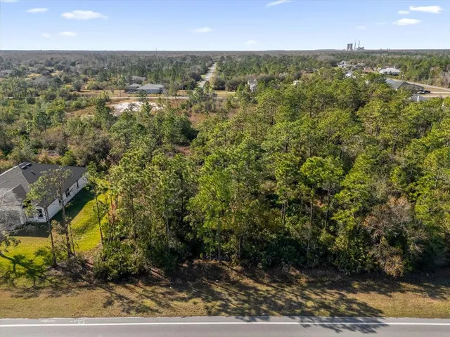 an aerial view of residential houses with outdoor space and trees